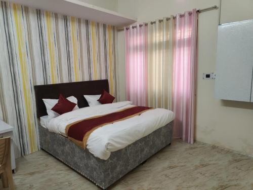 a bedroom with a large bed with red pillows at Veer Guest House in Bareilly