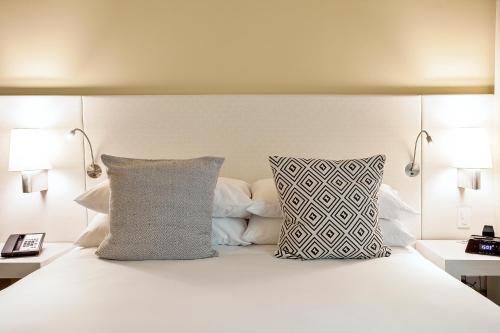 a bedroom with a white bed with two pillows at Movich Buro 26 in Bogotá
