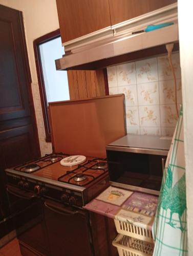 a kitchen with a stove and a microwave at Casa RMF alla Fontana in Valsolda