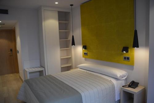 a bedroom with a bed with a green painting on the wall at Hotel Bilbao Plaza in Bilbao