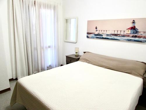 a bedroom with a white bed and a lighthouse at Casa KePi in Olbia