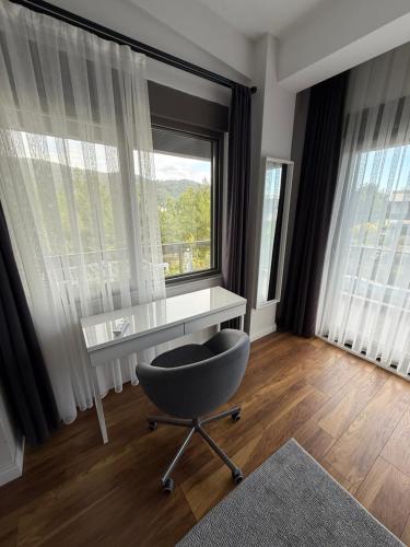 a desk and a chair in a room with windows at Canyon Villa Göynük Kemer Antalya with Pool in Antalya
