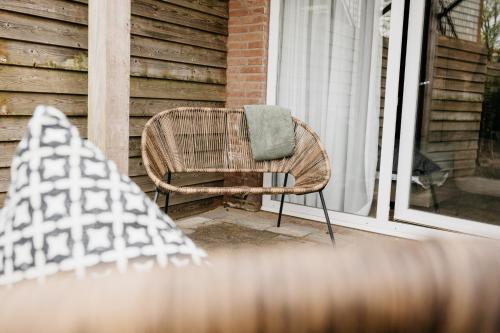 a wicker chair sitting on a porch next to a window at Hotel Janssen in Valkenburg