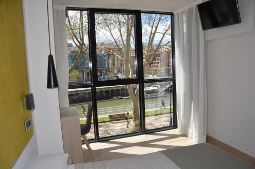 a room with a large window looking out at a tennis court at Hotel Bilbao Plaza in Bilbao