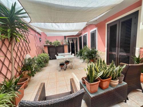 a patio with plants and a table and chairs at B&B Epos Acitrezza in Acitrezza