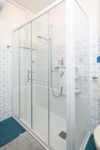a shower with glass doors in a bathroom at Oasi blu - Charme nel cuore della pineta in Grado-Pineta
