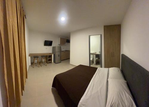 a bedroom with a bed and a table in a room at apartamentos villa 1blanca in Popayan