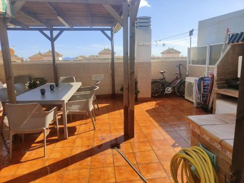 a patio with a table and chairs on a roof at Vivienda en Costa Narejos in Los Alcázares