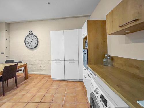a kitchen with a table and a clock on the wall at Séjour authentique en plein centre d Avignon in Avignon