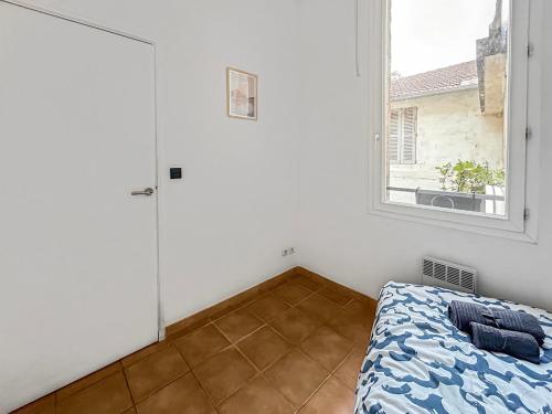 a bedroom with a bed and a window at Séjour authentique en plein centre d Avignon in Avignon