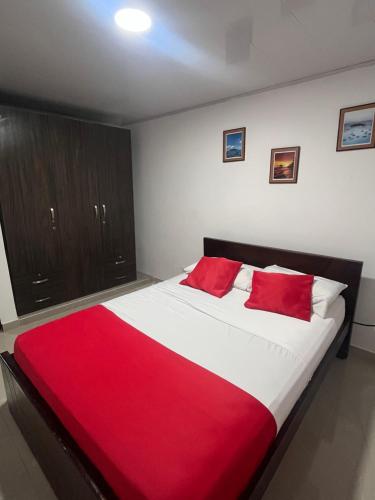 a bedroom with a large bed with red pillows at TAYLOR`S SWEET HOME in San Andrés