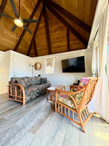 a living room with a couch and a tv at Ocean-View 1BR Condo on Black Sands Beach, Pool, Hot Tub in Pahala