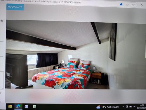 - une chambre avec un lit et une couverture colorée dans l'établissement Charmante maison bord de mer avec vue sur le port, au Cap d'Agde