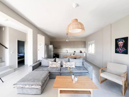 a living room with a couch and a table at Casa De Vara in Nea Potidaea
