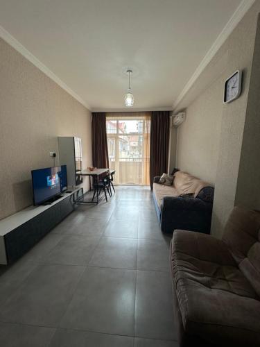 a living room with a couch and a television at Sweet Home Saburtalo in Tbilisi City