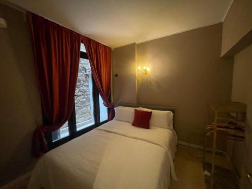 a bedroom with a white bed with a window at Prestige Suite Sirmione in Sirmione