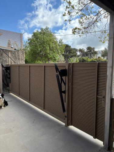 a fence with wooden shutters on the side of a building at קסם גלילי in Ma'alot Tarshiha
