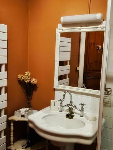 une salle de bain avec un lavabo et un miroir dans l'établissement L'Entrée Chambres d'Hôtes Bar & Restaurant, à Castillonnès