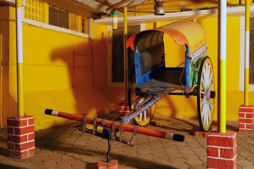 a cart parked in front of a yellow building at Le Royal Resort- By the Beach in Tarangambādi