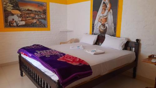 a bed in a room with a picture of a bride at Le Royal Resort- By the Beach in Tarangambādi