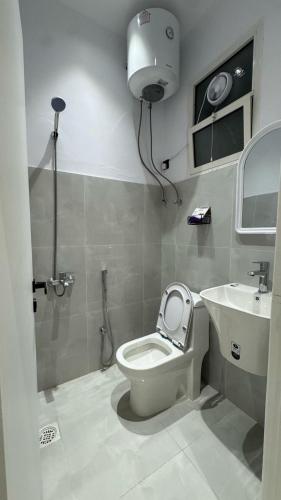 a bathroom with a toilet and a sink at Luxury Smart Entry Studio in Buraydah