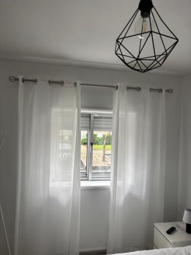 - une chambre avec des rideaux blancs et une fenêtre dans l'établissement Mima House Al, à Aveiro