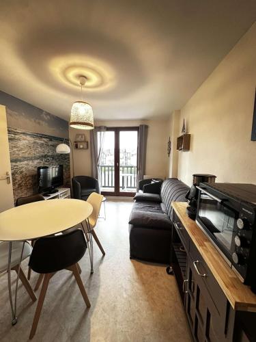 un salon avec un canapé et une table dans l'établissement horizon détente, 2 pas de la mer, à Ouistreham