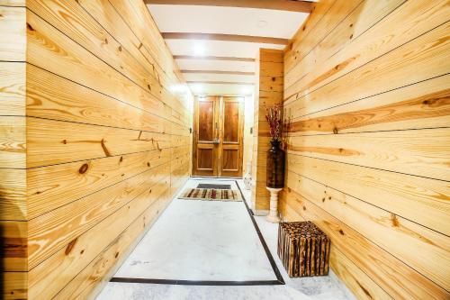 a room with wooden walls and a hallway with a bench at Jaipur The Lodge B&B in Jaipur