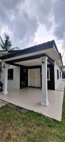 a small white house with a blue roof at Laman Mesra Qaseh in Merlimau