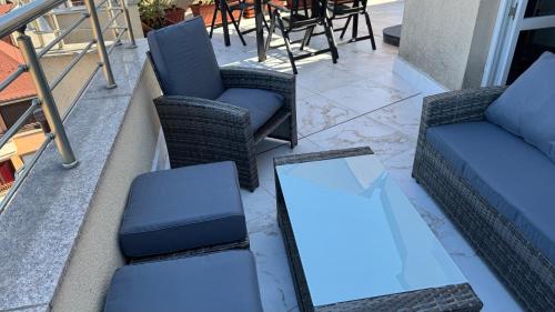 a patio with chairs and a table and a couch at Apartment near Vitosha mountain, self check-in, with underground parking in Sofia