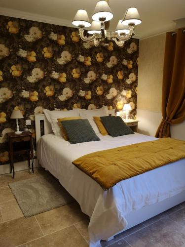 - une chambre avec un lit orné d'un mur fleuri dans l'établissement Gîte Le Mas des Agapes, à Beaucaire