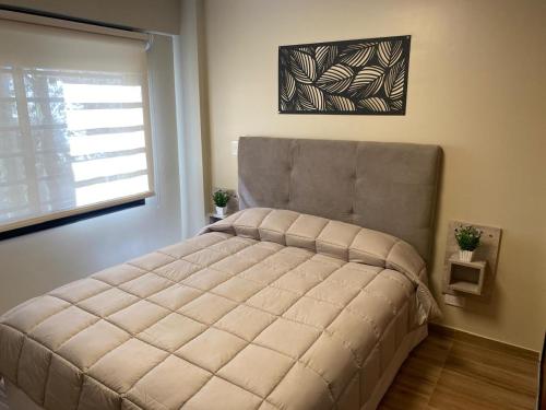 Una cama grande en un dormitorio con ventana. en Complejo Médanos II, en San Bernardo