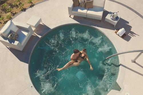 a man in a swimming pool in the water at Secrets Puerto Los Cabos Golf & Spa18+ in San José del Cabo