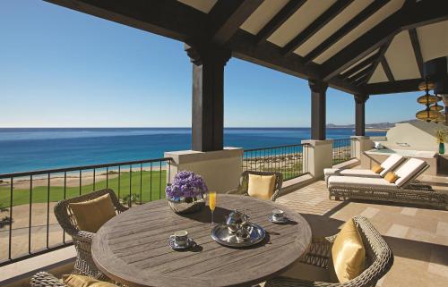a table on a balcony with a view of the ocean at Secrets Puerto Los Cabos Golf & Spa18+ in San José del Cabo