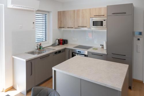a kitchen with white appliances and a white counter top at Amaria Downtown Aparthotel Villach in Villach