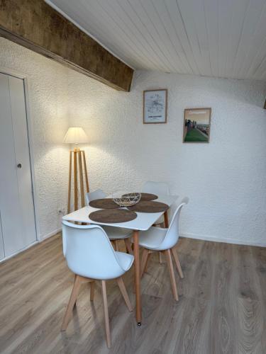 une salle à manger avec une table et des chaises blanches dans l'établissement Le nid des remparts, à Carcassonne