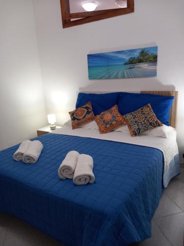 a bedroom with a blue bed with towels on it at Appartamento L'Orchidea in Forio d'Ischia