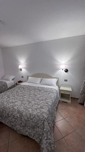 a bedroom with two beds and two lights on the wall at Hotel Terranova in Olbia