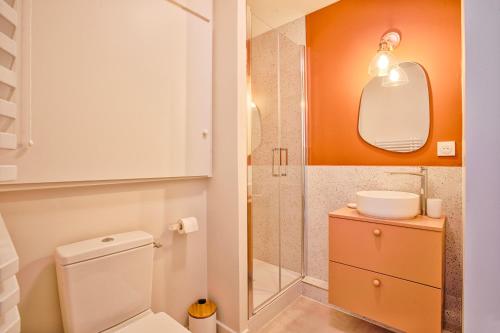 une salle de bain avec toilettes, lavabo et miroir dans l'établissement Appt cosy Cabourg 2 min plage 5 min thalasso, à Cabourg