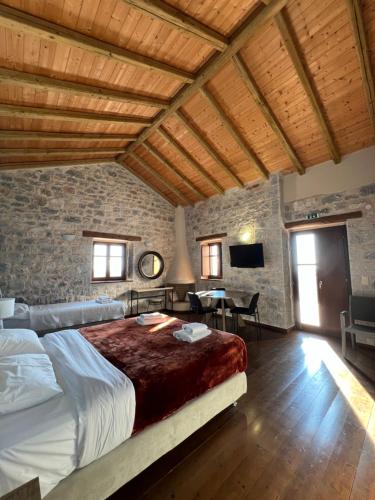 a bedroom with a large bed and a stone wall at Koukouri Village in Kafióna