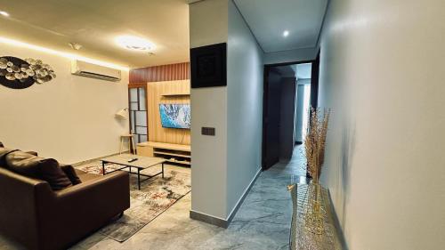 a living room with a couch and a table at The H Tower Rasuna Suites Kuningan Jakarta By Villaloka in Jakarta