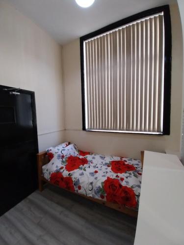a bedroom with a bed and a window with flowers at Queens Hotel in Blackburn