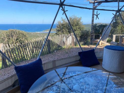 d'une terrasse avec une table et une vue sur l'océan. dans l'établissement Mare, à Porto-Vecchio