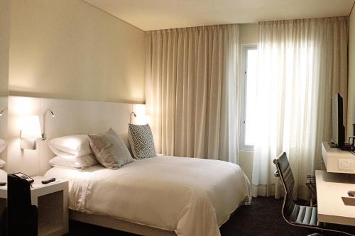 a hotel room with a bed and a window at Movich Buro 26 in Bogotá