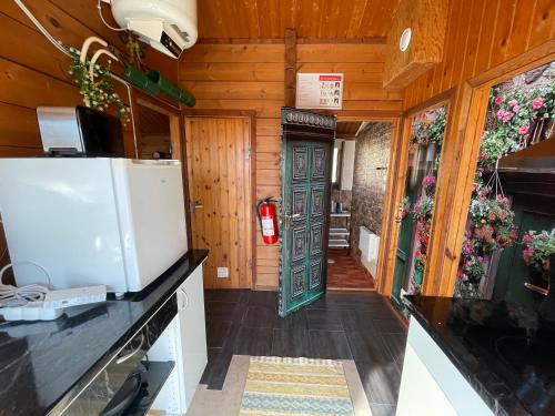 a kitchen with wooden walls and a refrigerator at Three Rooms stuga i stugby near National Park in Undenäs