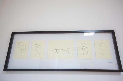 a picture frame with drawings of animals on a wall at Hostel Kosy in Rijeka