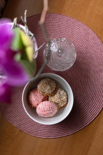 a bowl of donuts on a plate next to a glass at APARTAMENTY VILLA PIGMALION - sauna, jacuzzi, parking, ogród in Kudowa-Zdrój