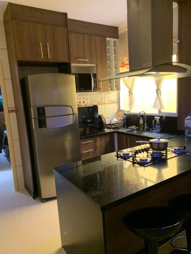 a kitchen with a stainless steel refrigerator and a counter at Casa Angélica in Guarulhos