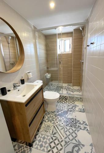 a bathroom with a sink and a toilet and a mirror at Apartamento El Sol in Piles