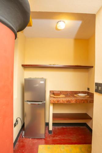 a kitchen with a stainless steel refrigerator and a table at Lake Arenal Hotel & Brewery in Tilarán